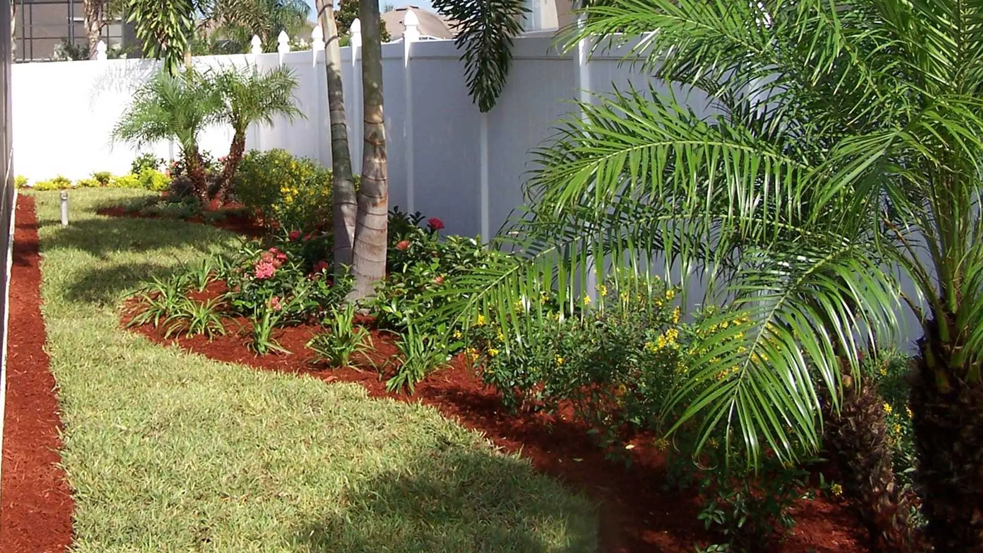 Red mulch laid in a new landscaping bed around a property located in The Villages, FL.