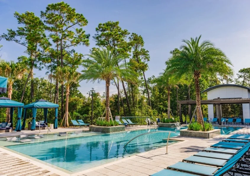 View of a home with palm trees and a patio with a pool in Winter Garden, FL.